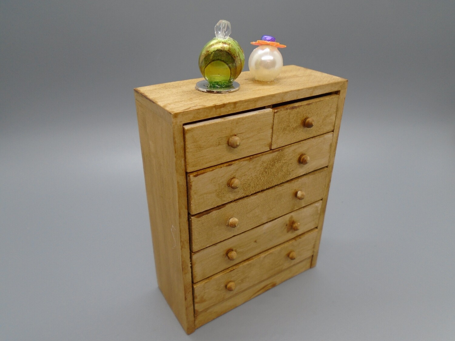 TALL WOOD STAINED CHEST WITH PERFUME BOTTLES