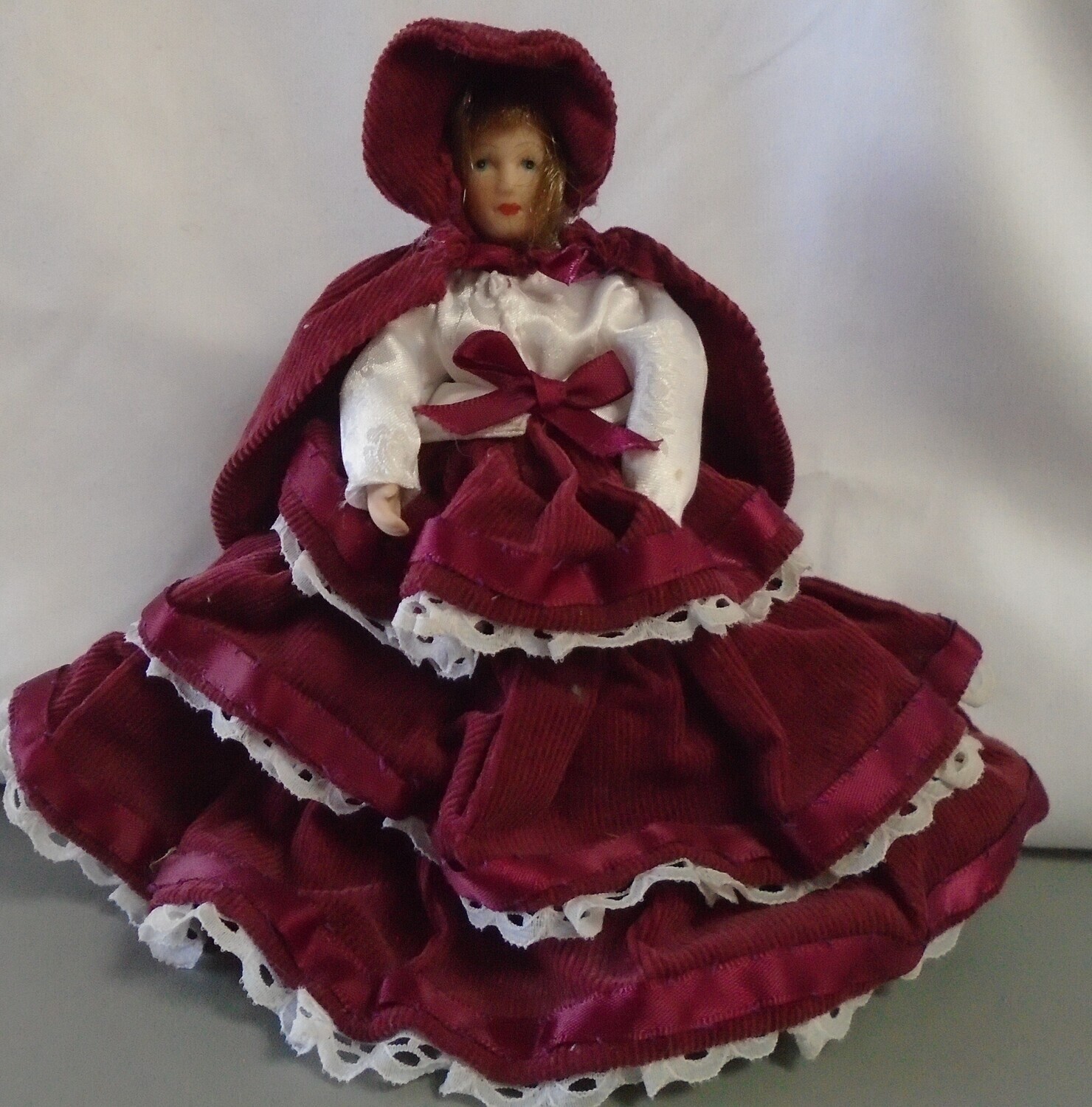 LADY IN MAROON DRESS, CAPE AND HAT