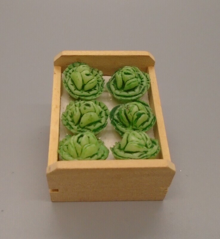 CRATE OF CABBAGES TILTED FOR DISPLAYING