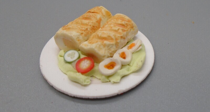 SAUSAGE ROLLS AND SALAD ON PLATE