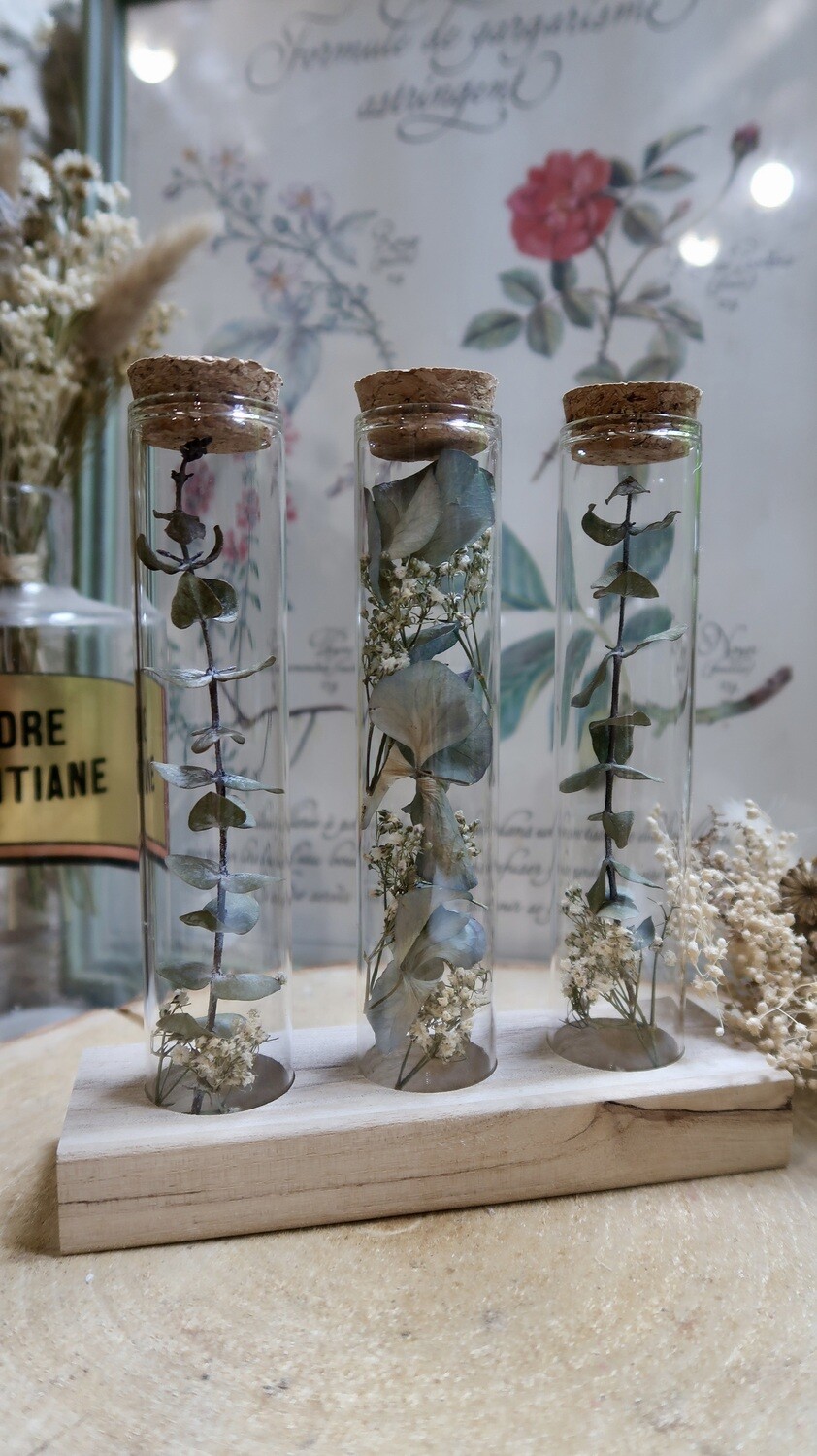 Trio de tubes fleuris sur socle en bois