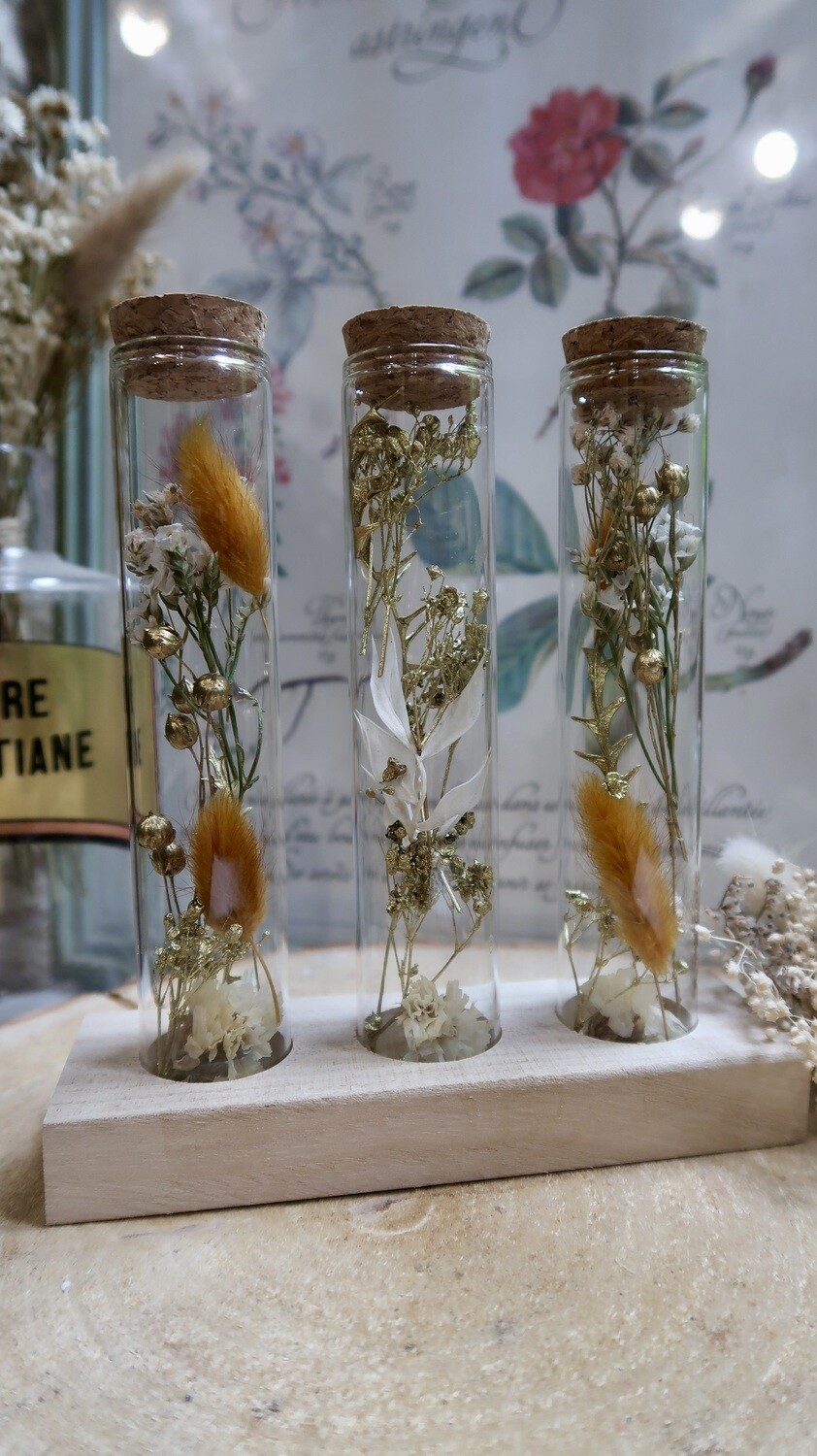 Trio de tubes fleuris sur socle en bois