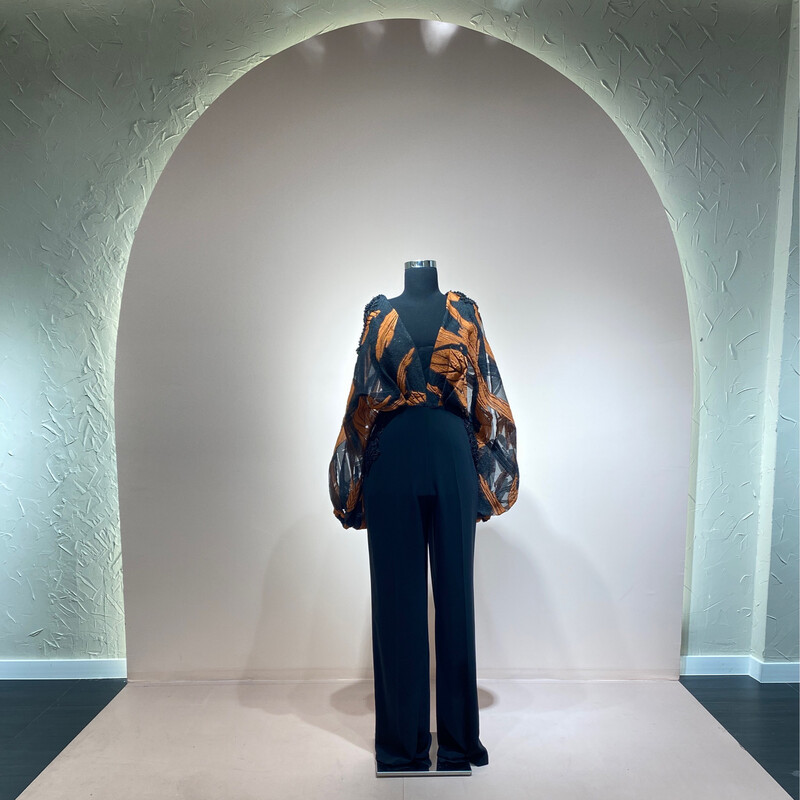 Jumpsuit con mangas, color negro y print anaranjado en tonalidad terracota. Talla  M