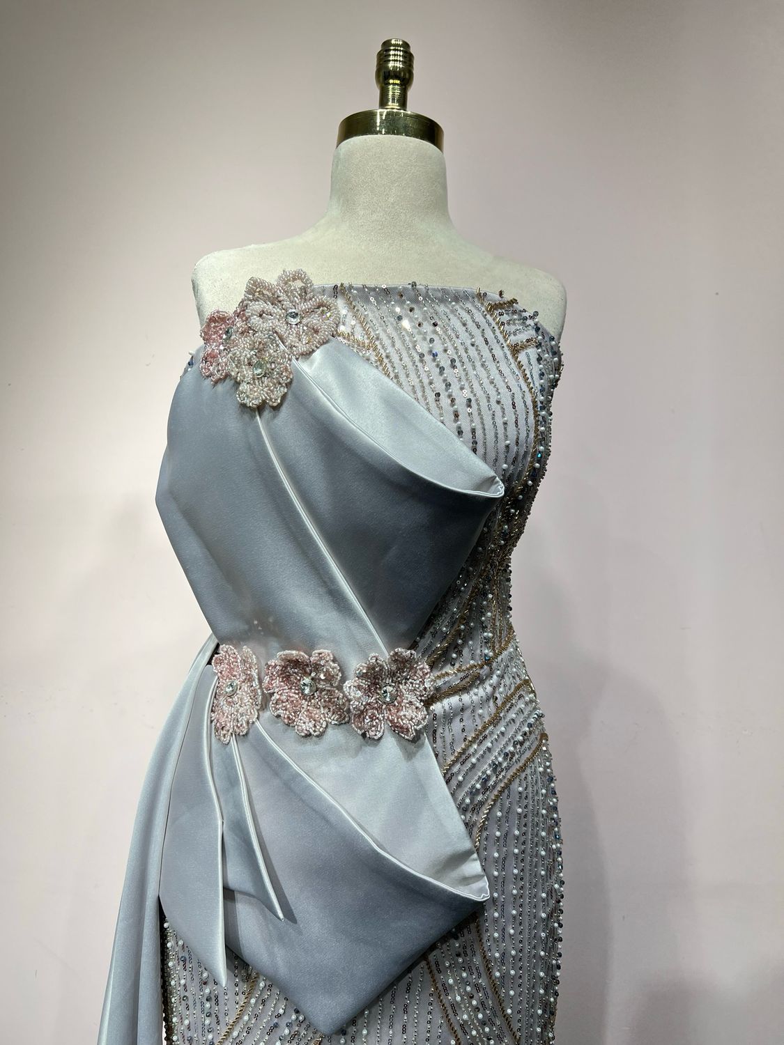Strapless silver gown with detailed beading, and a soft side drape