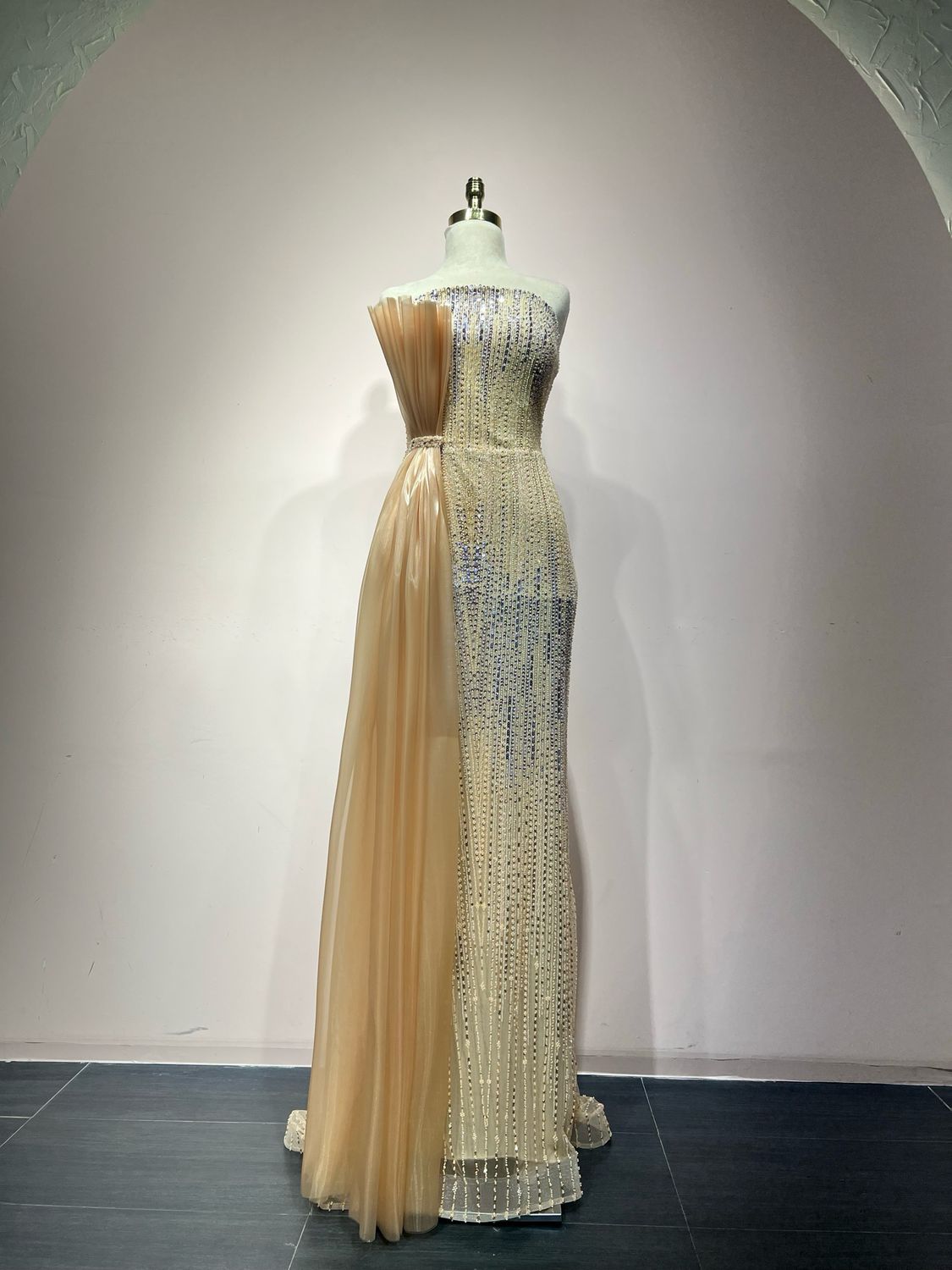 Sequined strapless gown with a champagne side drape.