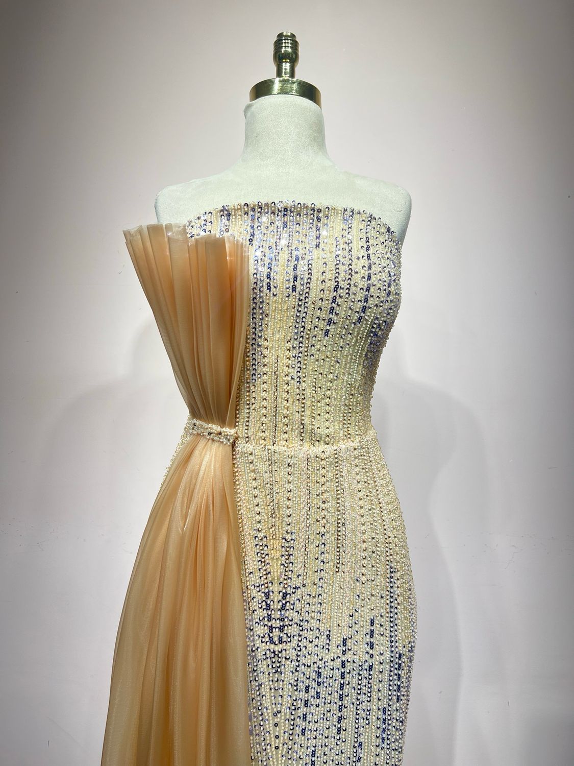 Sequined strapless gown with a champagne side drape.