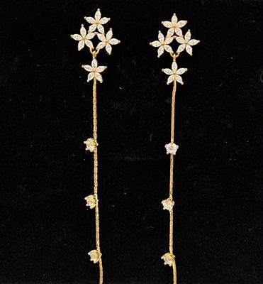 Aretes dorados de flores con linea de cristares