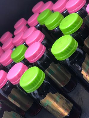 Photo of eldeberry syrup shots from Big Nate's Philly Pressed Juices. Shots have pink and green bottle caps.