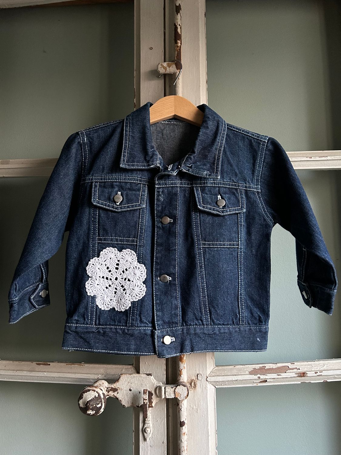 Spijkerjack meisje, denim (donkerblauw), met gehaakte rozet op de voor- en achterkant. Mt 98/104