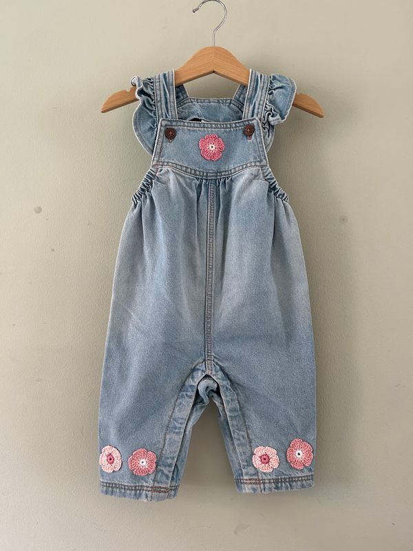 Baby tuinbroekje met gehaakte bloemetjes (rose/wit) en roezel schouderbandjes. Mt 74