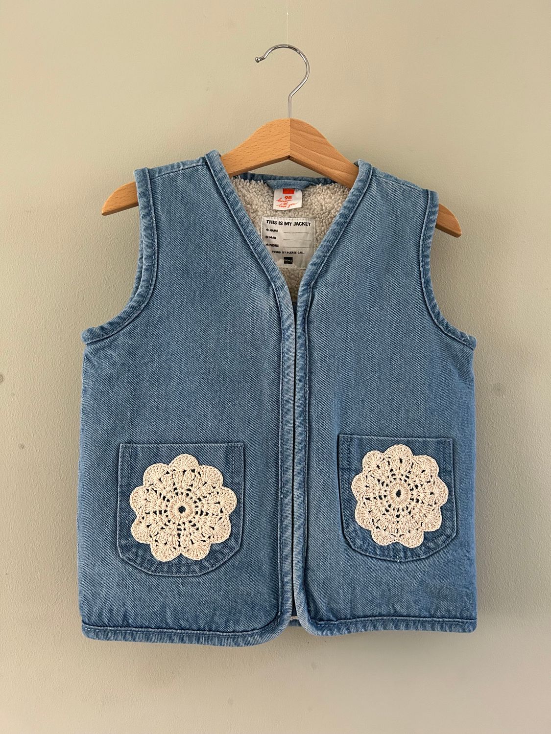 Kinder gilet lichtblauw denim, met gehaakte rozetten. Binnenkant teddy