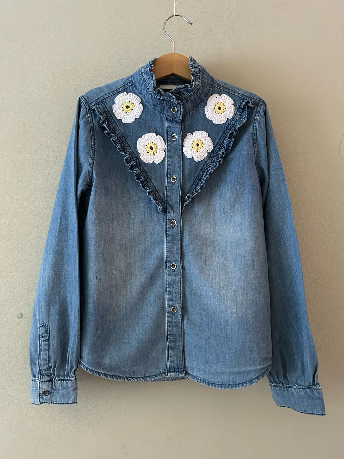 Kinderblouse met roezelrand en gehaakte madeliefjes. Mt 134/140