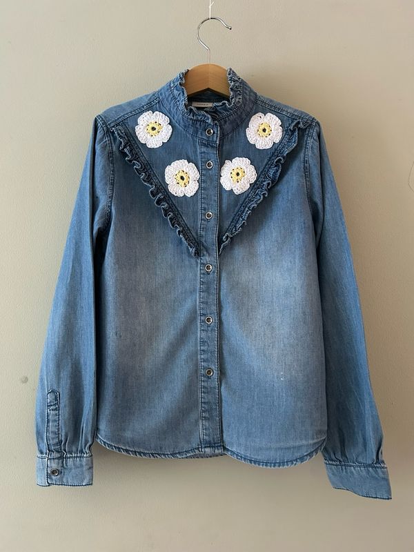 Kinderblouse met roezelrand en gehaakte madeliefjes. Mt 134/140