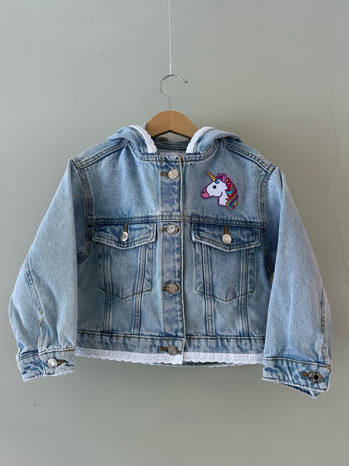 Kinder spijkerjackje met applicatie unicorn en broderie randje en capuchon. Mt 122