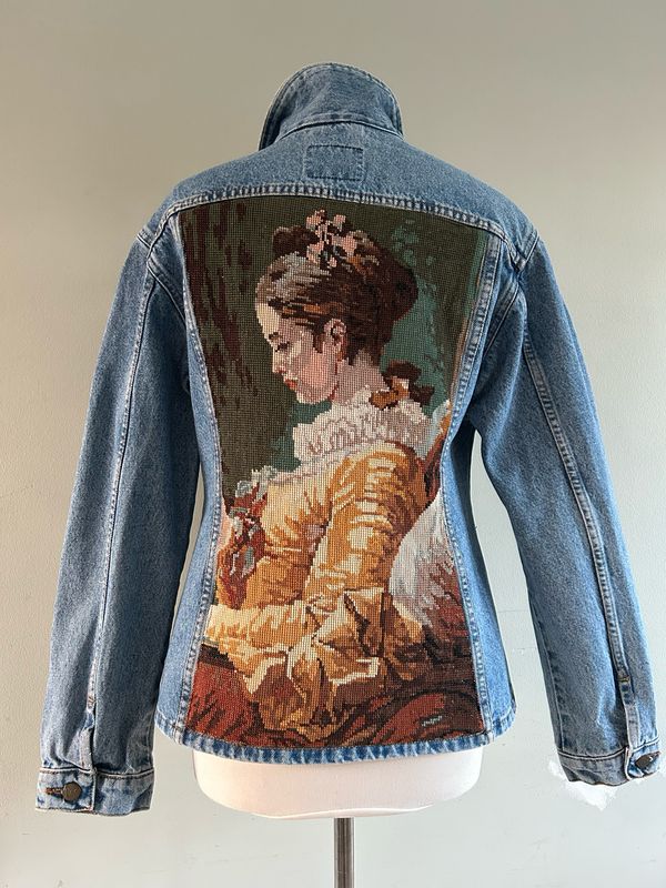 Spijkerjack lichtblauw denim met borduurwerk lezende dame op het rugpand
