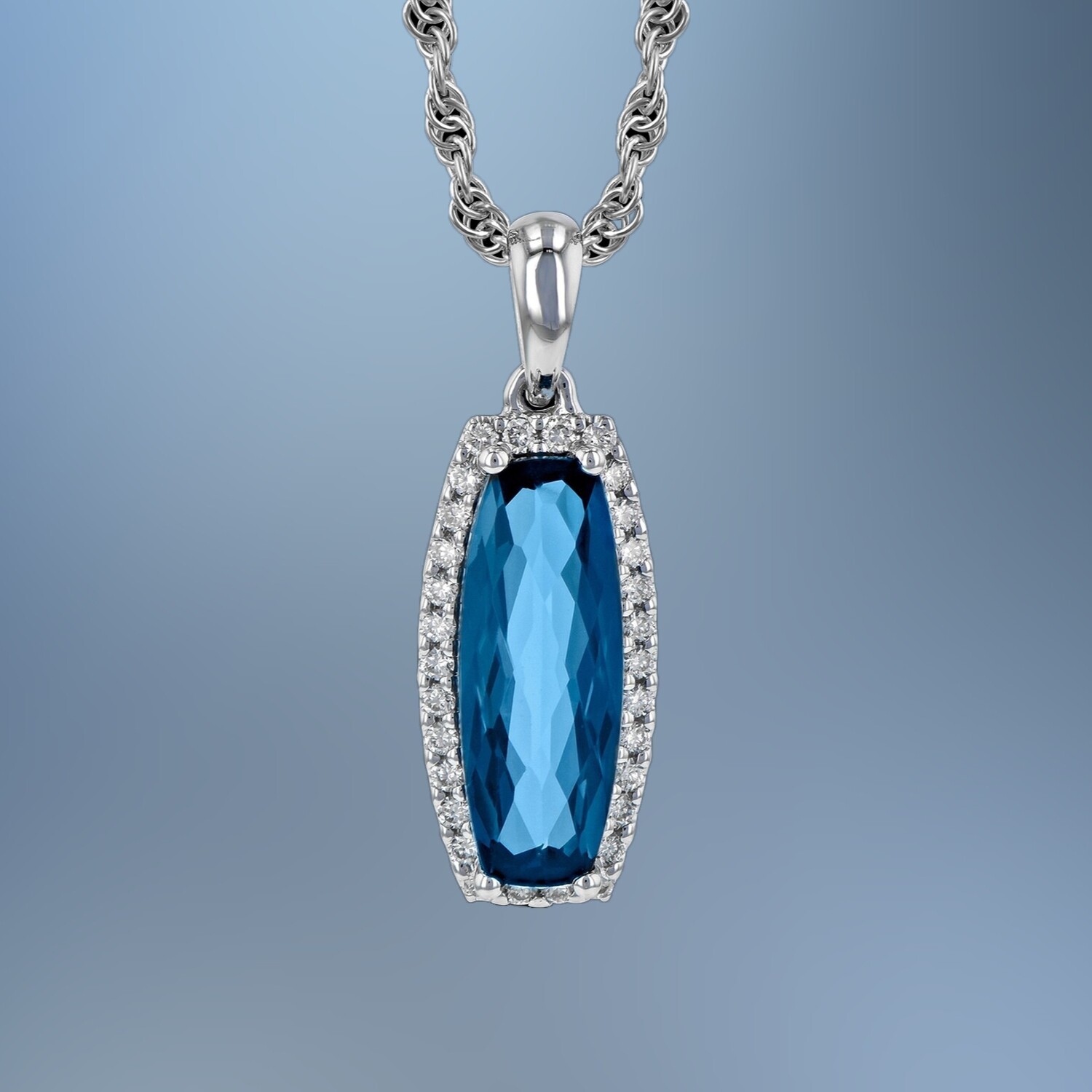 14KT WHITE GOLD BLUE TOPAZ & DIAMOND PENDANT FEATURING A 1.58 CT CUSHION CUT TOPAZ AND 30 ROUND BRILLIANT CUT DIAMONDS TOTALING 0.12 CTS