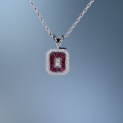 14KT WHITE GOLD BLOCK "O" RUBY & DIAMOND PENDANT FEATURING 36 ROUND BRILLIANT CUT DIAMONDS AND 2 PRINCESS CUT DIAMONDS TOTALING 0.22 CTS. ALSO FEATURING 14 RUBY BAGETTES TOTALING 0.84 CTS