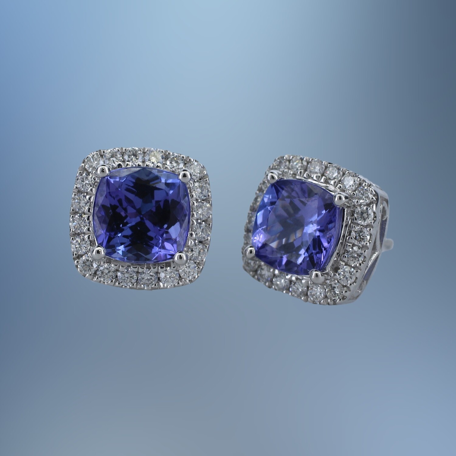 14 KT WHITE GOLD TANZANITE & DIAMOND STUD EARRINGS FEATURING 2 CUSHION CUT TANZANITES TOTALING 3.10 CTS AND 40 ROUND BRILLIANT CUT DIAMONDS TOTALING 0.50 CTS