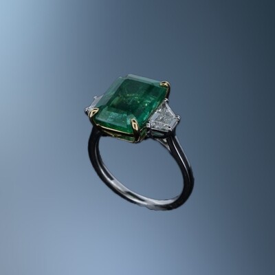 PLATINUM & 18KT EMERALD & DIAMOND RING FEATURING 1 EMERALD TOTALING 4.88 CTS AND 2 TRAPEZOID DIAMONDS TOTALING .69 CTS