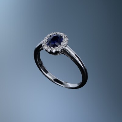 18KT WHITE GOLD DIAMOND & SAPPHIRE HALO STYLE RING FEATURING ONE OVAL SAPPHIRE TOTALING 0.59 CTS AND 14 ROUND BRILLIANT CUT DIAMONDS TOTALING .18 CTS