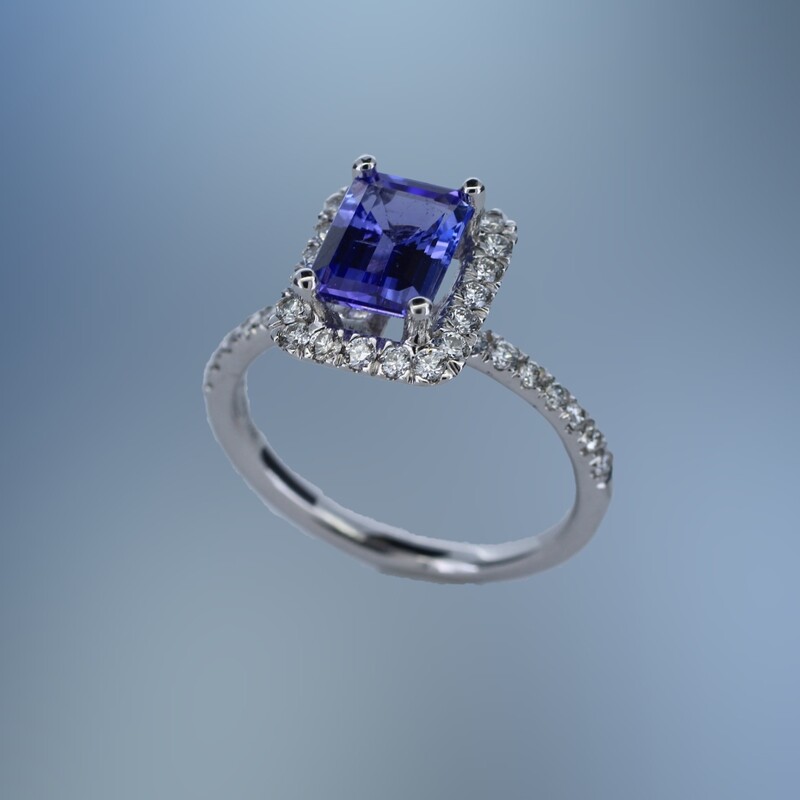 14KT WHITE GOLD TANZANITE AND DIAMOND HALO STYLE RING FEATURING ONE 1.61 CT EMERALD CUT TANZANITE WITH 34 ROUND BRILLIANT CUT DIAMONDS TOTALING .49 CTS.
