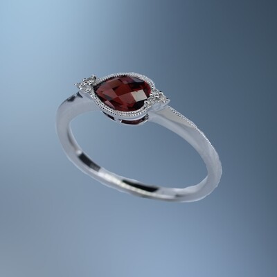 ONE 14KT WHITE GOLD LADIES GARNET AND DIAMOND RING CONTAINING ONE .66 CT PEAR SHAPE GARNET SET EAST/WEST, AND .03 CTS OF NATURAL ROUND BRILLIANT CUT DIAMONDS