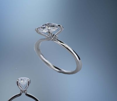 ONE 14KT WHITE GOLD ENGAGEMENT RING FEATURING A DIAMOND HALO  AT THE BASE OF THE CENTER STONE