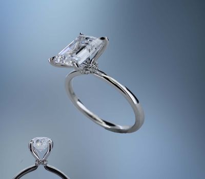ONE 14KT WHITE GOLD ENGAGEMENT RING FEATURING A DIAMOND HALO AT THE BASE OF THE CENTER STONE ONE 14KT WHITE GOLD ENGAGEMENT RING FEATURING A DIAMOND HALO AT THE BASE OF THE CENTER STONE