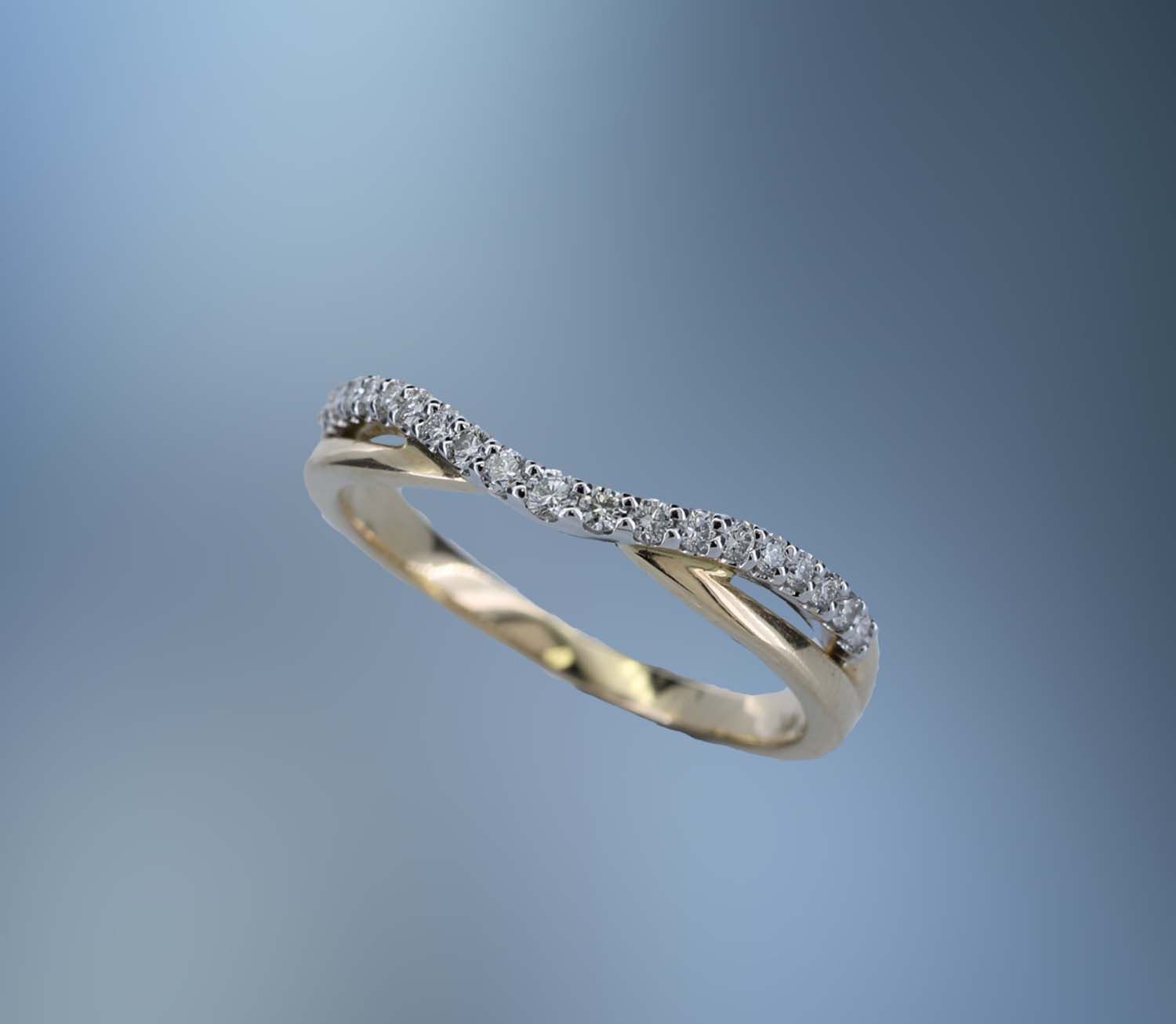 14 KARAT YELLOW GOLD CONTOURED BAND CONTAINING 19 ROUND BRILLIANT CUT DIAMONDS TOTALING 0.17 CARATS 14 KARAT YELLOW GOLD CONTOURED BAND CONTAINING 19 ROUND BRILLIANT CUT DIAMONDS TOTALING 0.17 CARATS 