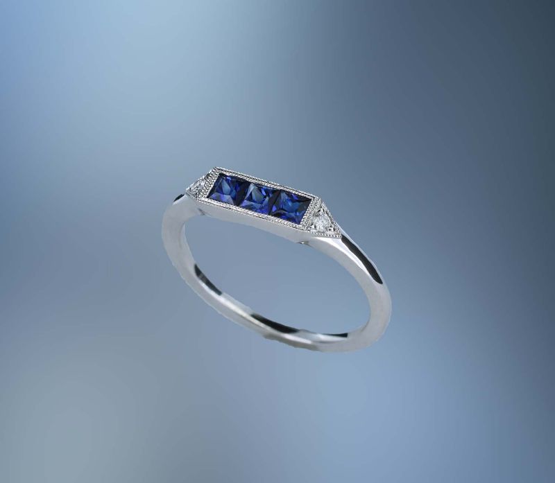 14KT WHITE GOLD SAPPHIRE  & DIAMOND BAND FEATURING 3 PRINCESS CUT SAPPHIRES TOTALING .46 CTS & 2 ROUND BRILLIANT DIAMONDS TOTALING .04 CTS