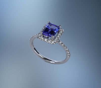 14KT WHITE GOLD TANZANITE AND DIAMOND HALO STYLE RING FEATURING  ONE 1.61 CT EMERALD CUT TANZANITE WITH 34 ROUND BRILLIANT CUT DIAMONDS TOTALING .49 CTS.