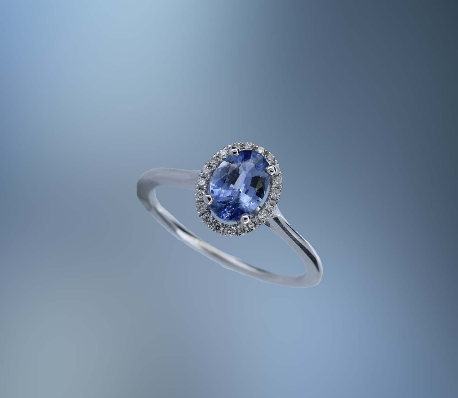 18KT WHITE GOLD DIAMOND & SAPPHIRE RING FEATURING 1 OVAL SAPPHIRE TOTALING 0.89 CTS AND 20 ROUND BRILLIANT CUT DIAMONDS TOTALING .10 CTS 18KT WHITE GOLD DIAMOND & SAPPHIRE RING FEATURING 1 OVAL SAPPHIRE TOTALING 0.89 CTS AND 20 ROUND BRILLIANT CUT DIAMONDS TOTALING .10 CTS