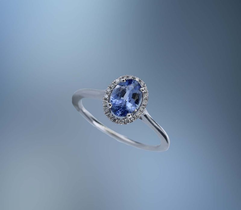 18KT WHITE GOLD DIAMOND & SAPPHIRE RING FEATURING 1 OVAL  SAPPHIRE TOTALING 0.89 CTS AND 20 ROUND BRILLIANT CUT DIAMONDS TOTALING .10 CTS