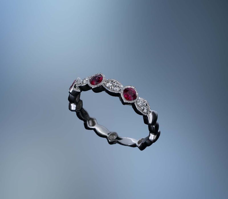 18KT WHITE GOLD DIAMOND & RUBY BAND FEATURING 3 ROUND RUBIES TOTALING .32 CTS & 8 ROUND BRILLIANT DIAMONDS TOTALING .11 CTS