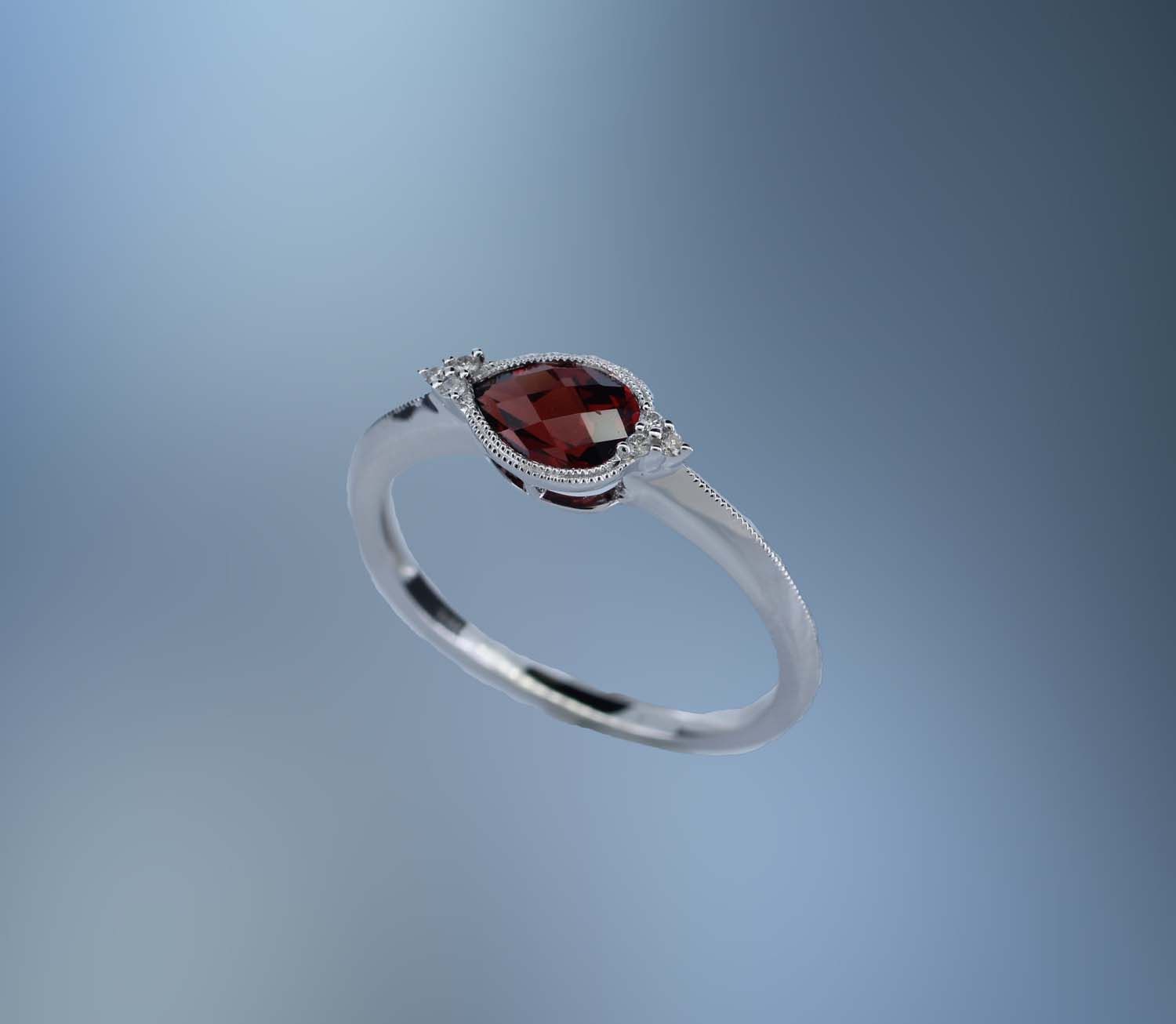 ONE 14KT WHITE GOLD LADIES GARNET AND DIAMOND RING CONTAINING ONE .66 CT PEAR SHAPE GARNET SET EAST/WEST, AND .03 CTS OF NATURAL ROUND BRILLIANT CUT DIAMONDS ONE 14KT WHITE GOLD LADIES GARNET AND DIAMOND RING CONTAINING ONE .66 CT PEAR SHAPE GARNET SET EAST/WEST, AND .03 CTS OF NATURAL ROUND BRILLIANT CUT DIAMONDS