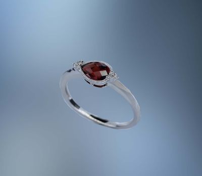 ONE 14KT WHITE GOLD LADIES GARNET AND DIAMOND RING CONTAINING ONE .66 CT PEAR SHAPE GARNET SET EAST/WEST, AND .03 CTS OF NATURAL ROUND BRILLIANT CUT DIAMONDS ONE 14KT WHITE GOLD LADIES GARNET AND DIAMOND RING CONTAINING ONE .66 CT PEAR SHAPE GARNET SET EAST/WEST, AND .03 CTS OF NATURAL ROUND BRILLIANT CUT DIAMONDS