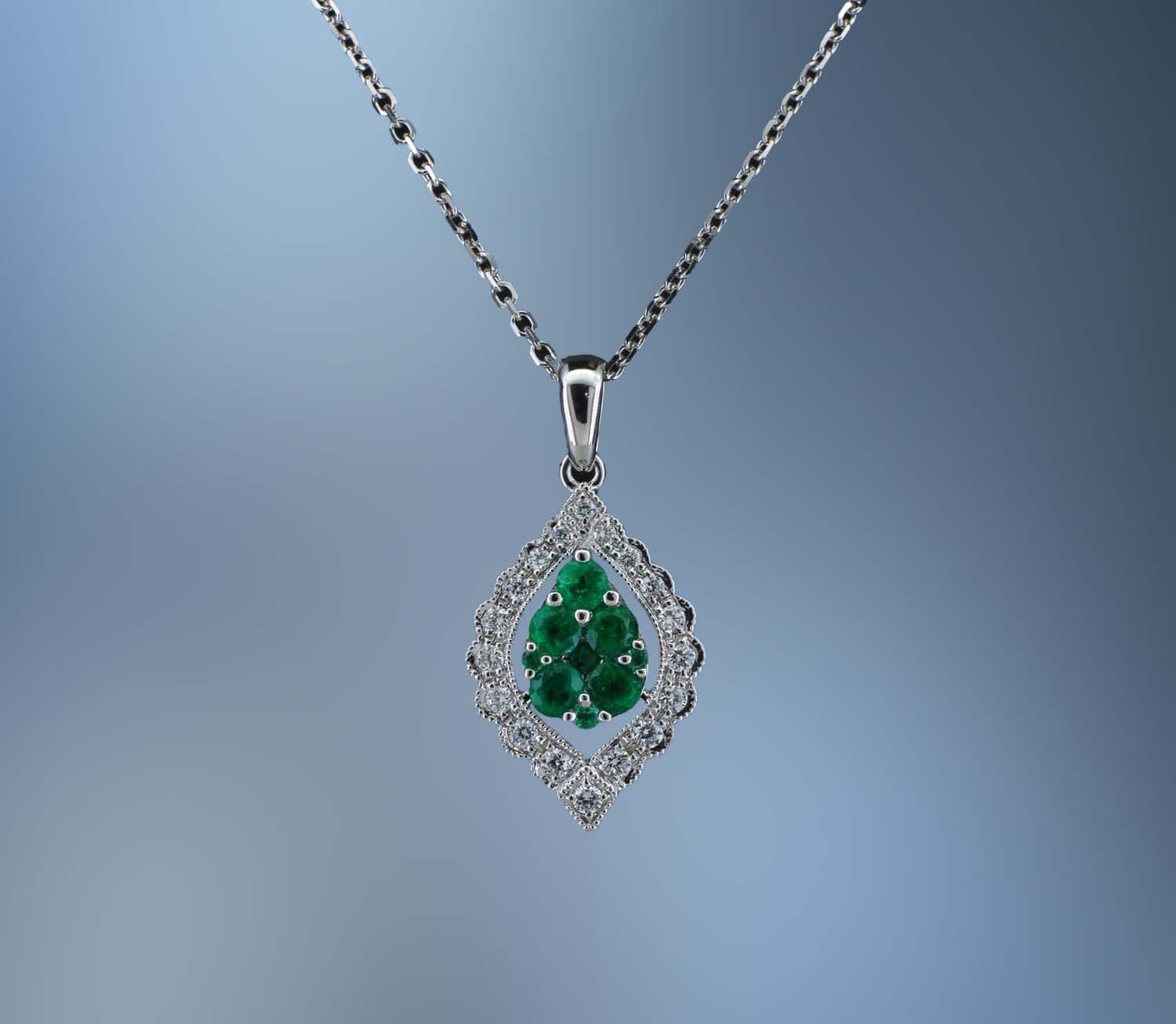 14KT WHITE GOLD EMERALD & DIAMOND PENDANT FEATURING 5 ROUND BRILLIANT CUT EMERALDS TOTALING .38 CTS AND 18 ROUND BRILLIANT CUT DIAMONDS TOTALING .16 CTS WITH A 16 14KT WHITE GOLD EMERALD & DIAMOND PENDANT FEATURING 5 ROUND BRILLIANT CUT EMERALDS TOTALING .38 CTS AND 18 ROUND BRILLIANT CUT DIAMONDS TOTALING .16 CTS WITH A 16" CHAIN.