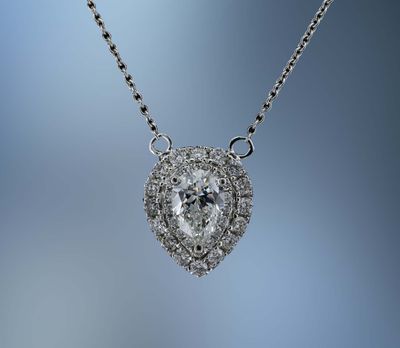 14KT WHITE GOLD HALO PENDANT FEATURING ONE .70 CT PEAR SHAPED DIAMOND & 33 ROUND BRILLIANT DIAMONDS TOTALING .30 CTS 14KT WHITE GOLD HALO PENDANT FEATURING ONE .70 CT PEAR SHAPED DIAMOND & 33 ROUND BRILLIANT DIAMONDS TOTALING .30 CTS