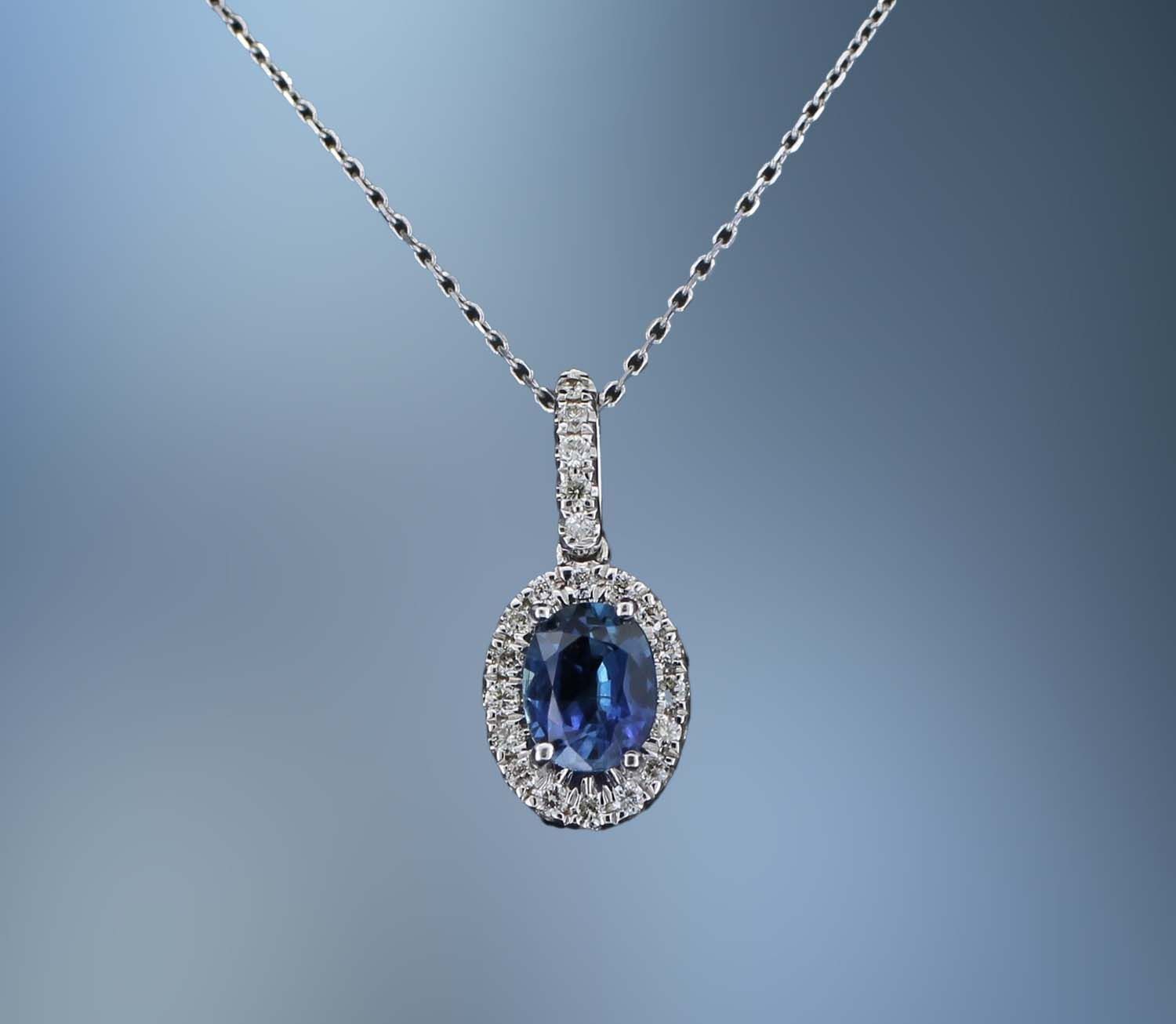 14KT WHITE GOLD PENDANT FEATURING 1 BLUE SAPPHIRE TOTALING 0.50 CTS AND 21 ROUND BRILLIANT CUT DIAMONDS TOTALING 0.11 CTS 14KT WHITE GOLD PENDANT FEATURING 1 BLUE SAPPHIRE TOTALING 0.50 CTS AND 21 ROUND BRILLIANT CUT DIAMONDS TOTALING 0.11 CTS