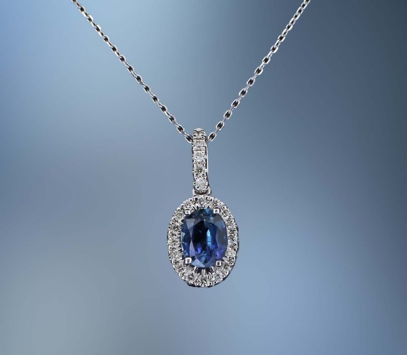 14KT WHITE GOLD PENDANT FEATURING 1 BLUE  SAPPHIRE TOTALING  0.50 CTS  AND 21 ROUND BRILLIANT CUT  DIAMONDS TOTALING 0.11 CTS