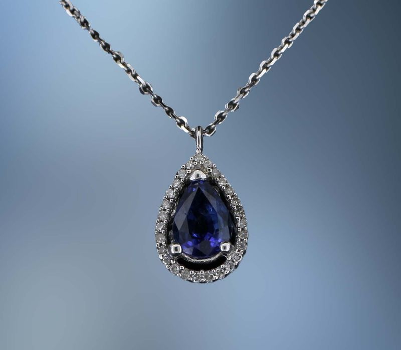 14KT WHITE GOLD PENDANT FEATURING  1 PEAR SHAPED NATURAL BLUE SAPPHIRE TOTALING 0.95 CTS  AND 27 ROUND BRILLIANT DIAMONDS TOTALING 0.08 CTS