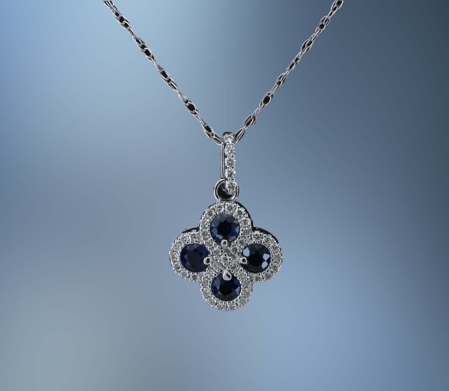 14KT WHITE GOLD SAPPHIRE AND DIAMOND PENDANT FEATURING 4 SAPPHIRES TOTALING .50 CTS AND 45 DIAMONDS TOTALING .20 CTS 14KT WHITE GOLD SAPPHIRE AND DIAMOND PENDANT FEATURING 4 SAPPHIRES TOTALING .50 CTS AND 45 DIAMONDS TOTALING .20 CTS