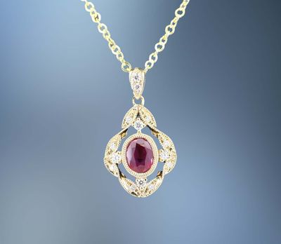 14KT YELLOW GOLD RUBY AND DIAMOND PENDANT FEATURING ONE  .39 CT. OVAL BRILLIANT CUT RUBY AND 12 ROUND BRILLIANT CUT DIAMONDS TOTALING .09 CTS.