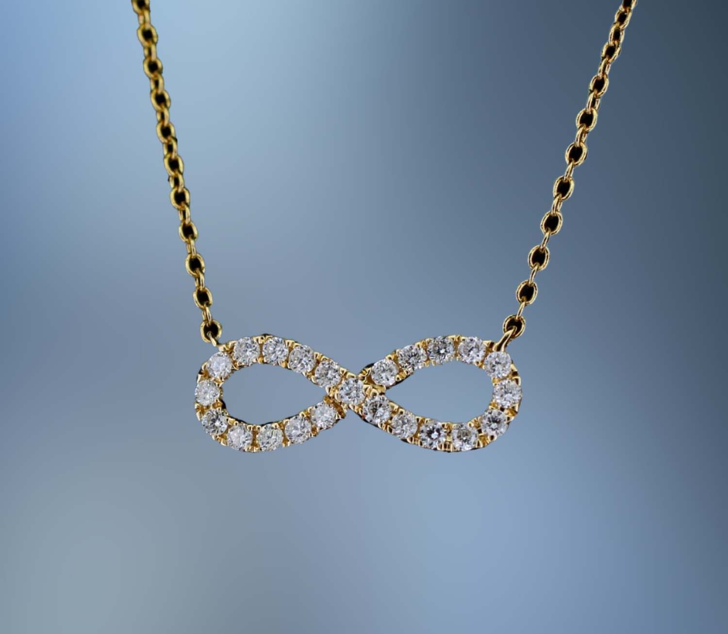 18 KT YELLOW GOLD INFINITY PENDANT FEATURING 23 ROUND BRILLIANT CUT DIAMONDS TOTALING 0.20 CTS 18 KT YELLOW GOLD INFINITY PENDANT FEATURING 23 ROUND BRILLIANT CUT DIAMONDS TOTALING 0.20 CTS