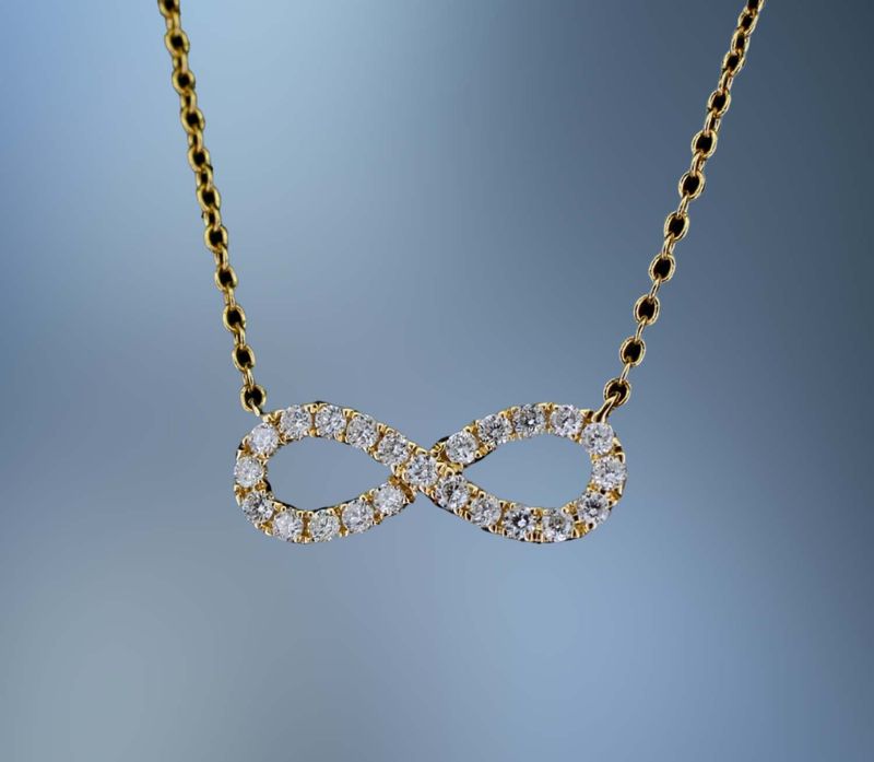 18 KT YELLOW GOLD INFINITY PENDANT FEATURING  23 ROUND BRILLIANT CUT DIAMONDS TOTALING 0.20 CTS
