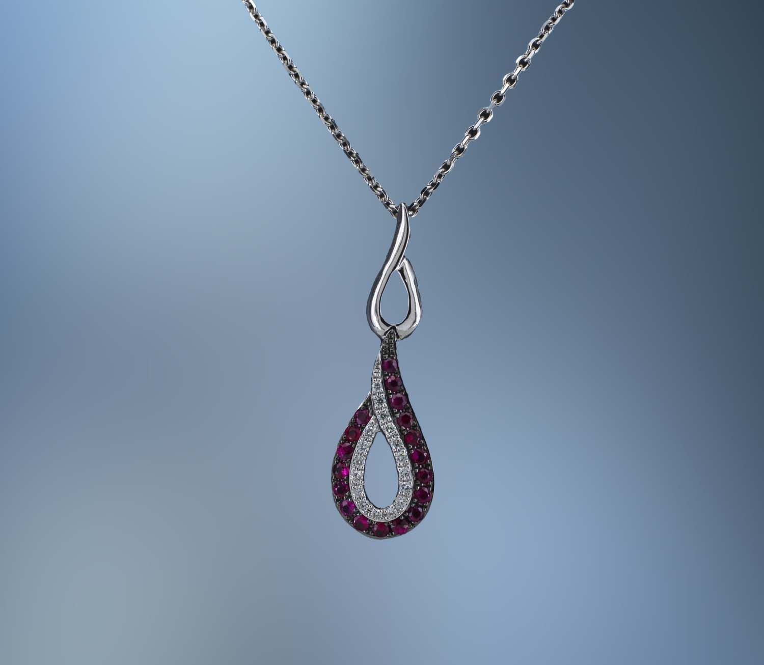 LADY'S 14KT WHITE GOLD LADY'S PENDANT FEATURING 18  ROUND BRILLIANT CUT  RUBYS TOTALING  .22 CTS  AND 17 ROUND BRILLIANT CUT  DIAMONDS TOTALING.06 CTS TW ON A 16" CHAIN