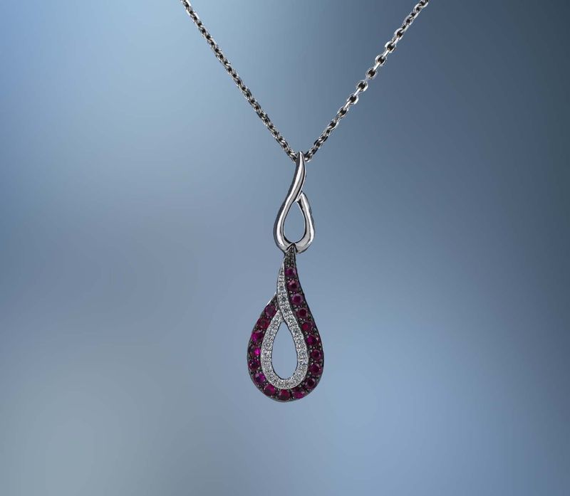 LADY'S 14KT WHITE GOLD LADY'S PENDANT FEATURING 18  ROUND BRILLIANT CUT  RUBYS TOTALING  .22 CTS  AND 17 ROUND BRILLIANT CUT  DIAMONDS TOTALING.06 CTS TW ON A 16" CHAIN