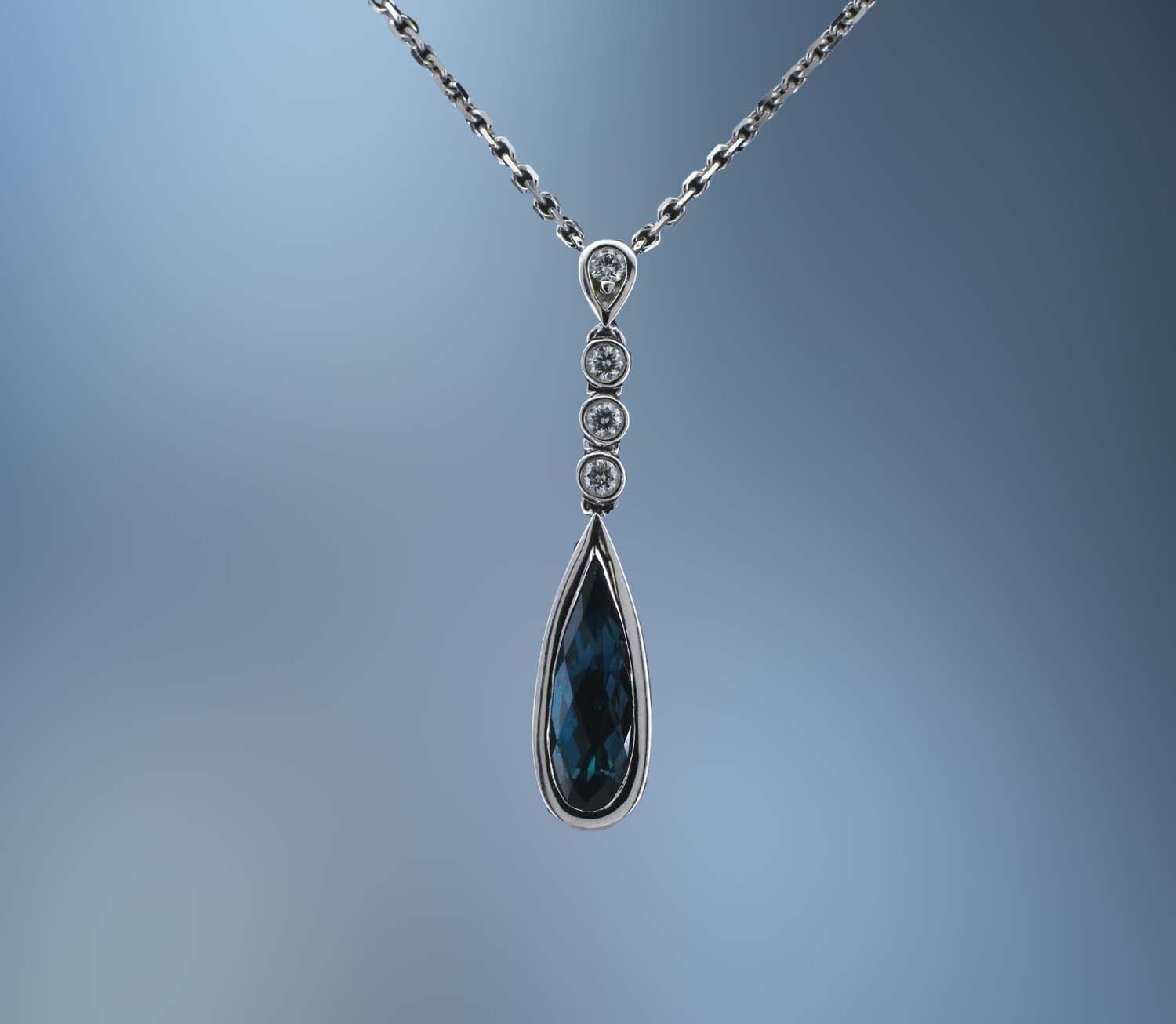 LADY'S 14KT WHITE GOLD BLUE TOPAZ & DIAMOND PENDANT FEATURING 1 FANTASY CUT BLUE TOPAZ AND 8 ROUND BRILLIANT CUT DIAMONDS TOTALING .15 CTS LADY'S 14KT WHITE GOLD BLUE TOPAZ & DIAMOND PENDANT FEATURING 1 FANTASY CUT BLUE TOPAZ AND 8 ROUND BRILLIANT CUT DIAMONDS TOTALING .15 CTS