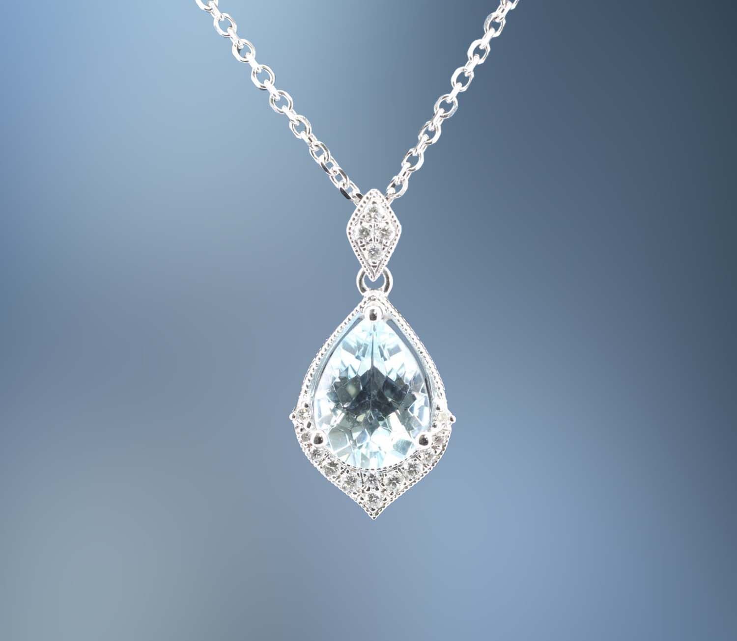 ONE 14KT WHITE GOLD AQUAMARINE AND DIAMOND PENDANT CONTAINING ONE 1.01 CT. PEAR SHAPE AQUAMARINE AND .08 CT. OF NATURAL ROUND BRILLIANT CUT DIAMONDS ON A 16 ONE 14KT WHITE GOLD AQUAMARINE AND DIAMOND PENDANT CONTAINING ONE 1.01 CT. PEAR SHAPE AQUAMARINE AND .08 CT. OF NATURAL ROUND BRILLIANT CUT DIAMONDS ON A 16" CABLE CHAIN WITH LOBSTER CLAW CLASP