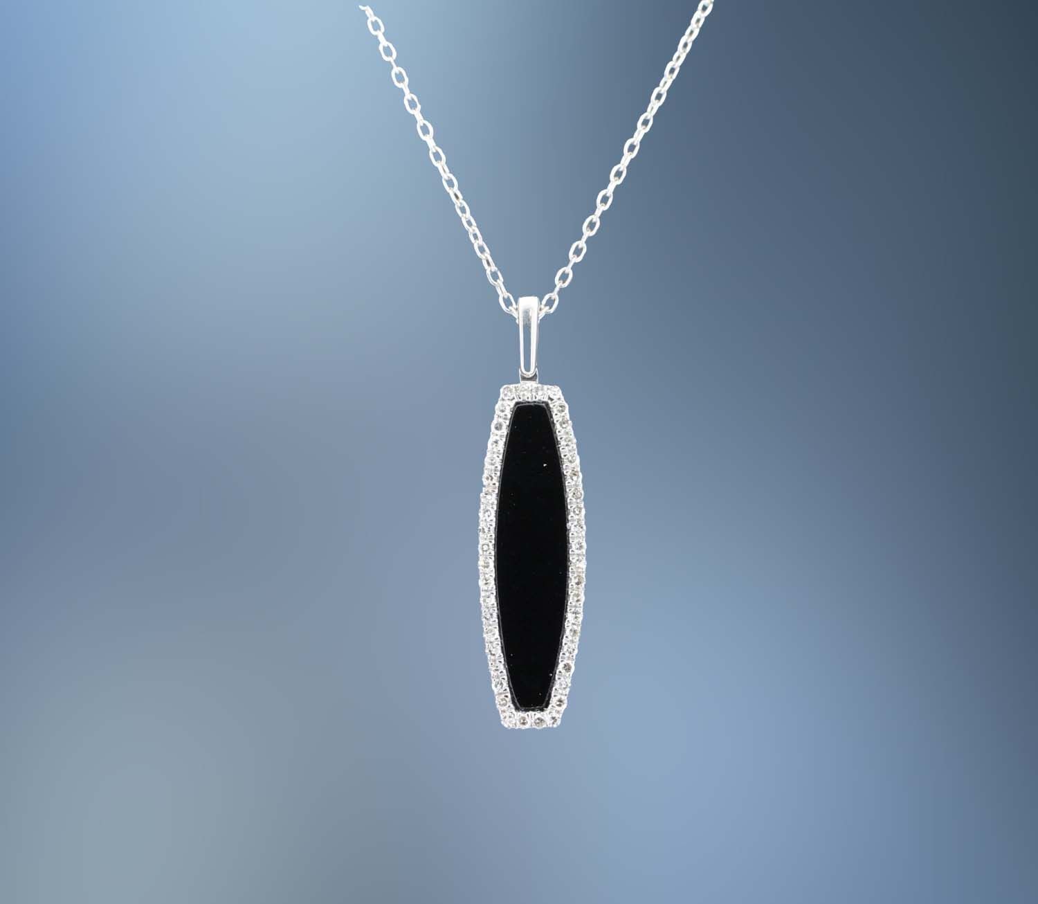 ONE 14KT WHITE GOLD LADIES DIAMOND AND ONYX PENDANT CONTAINING .13 CTTW OF NATURAL SINGLE CUT DIAMONDS SURROUNDING ONE 1.28 CT ONYX. ON AN 18" ADJUSTABLE CHAIN WITH A LOBSTER CLAW CLASP